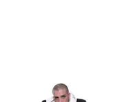 אלון דה לוקו יושב על הרצפה בחליפה שחורה